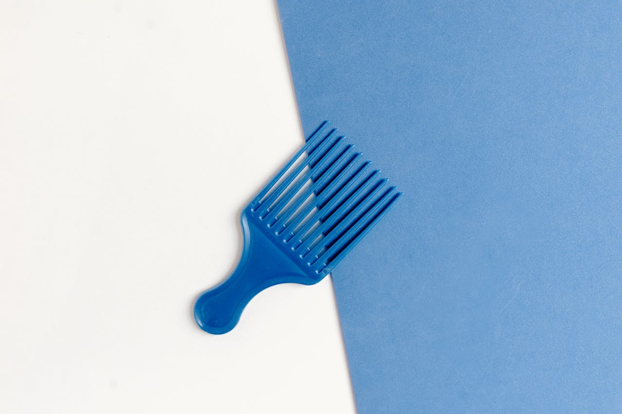 services-02 Stylish blue plastic comb on a dual-tone white and blue background.