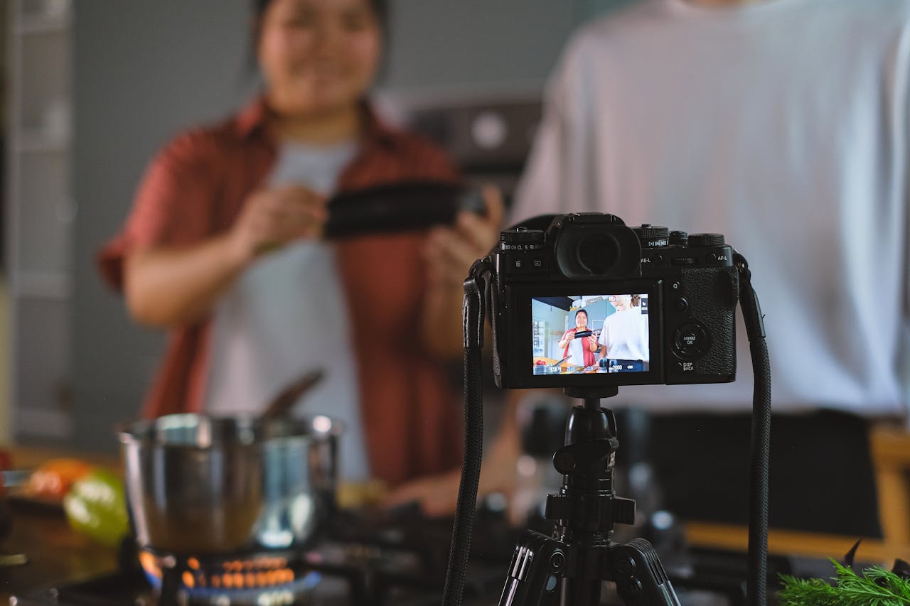 about-bg Behind-the-scenes setup of cooking video using a tripod-mounted camera in a kitchen.